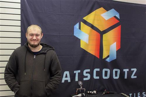  Jacob, posing for a photo in front of the Catscootz logo 